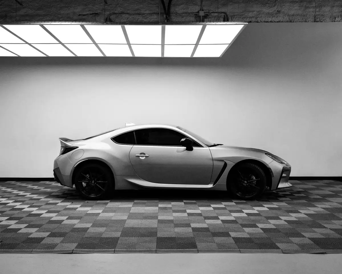A black and white photo of a car in a garage
